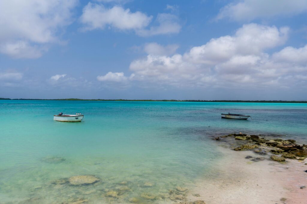 pexels photo 31713157 31713157 Serene view of turquoise waters and boats on Bonaire's coastline under a partly cloudy sky.