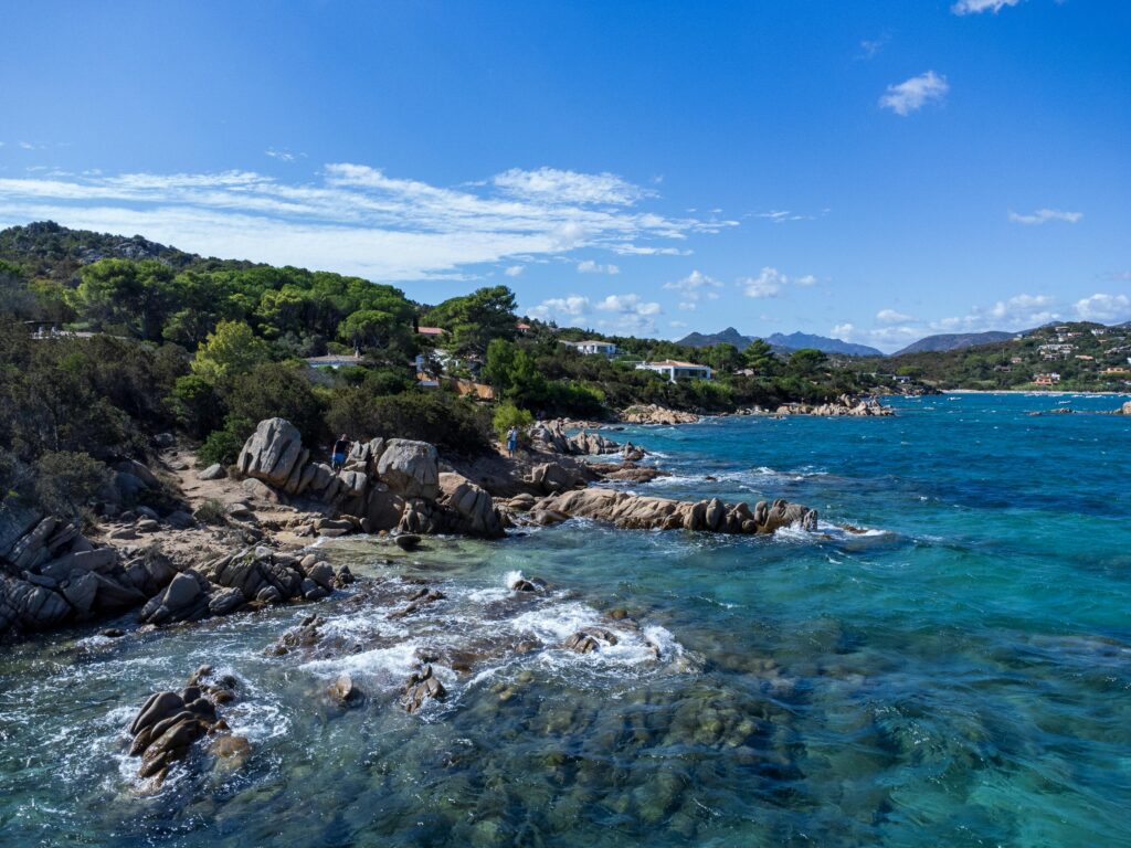 Insider's Guide to Sardinia Stunning coastal landscape in Sardinia, Italy with turquoise waters and rocky shoreline.